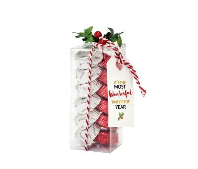 caja con bombones y rama de navidad decorada con tarjeta feliz año